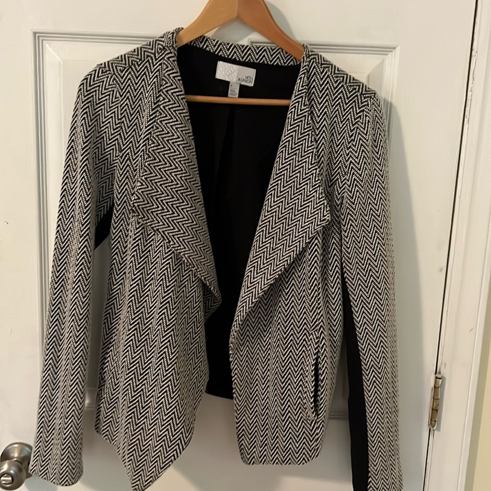 Black and white herringbone jacket . A symmetrical cut.